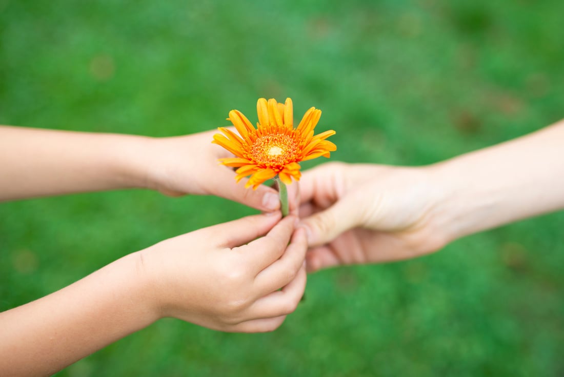 Parent and child handing flower